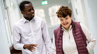 A learning disabilities nurse walking and talking with a patient.