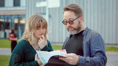 Parent and their adult child looking at an open day map together.