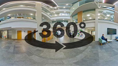 Still from virtual tour of campus showing interior of Bristol Business school, 360 degree swooshy arrows graphic superimposed.