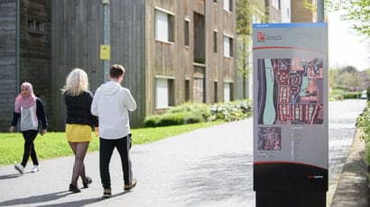 People walking around on Frenchay Campus outside an accommodation building.