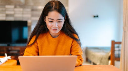 Prospective student using a laptop in their living room.