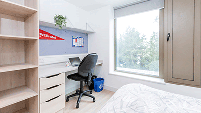 A standard bedroom at Kingfisher Court including a desk space, shelving and chair.