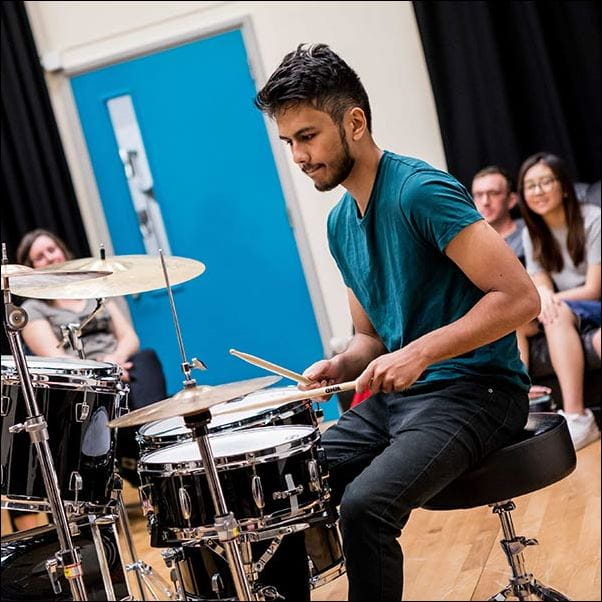 Student performing to people on the drums at the Centre for Music.