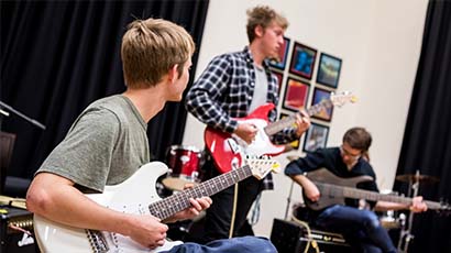 Music students playing electric guitar together.