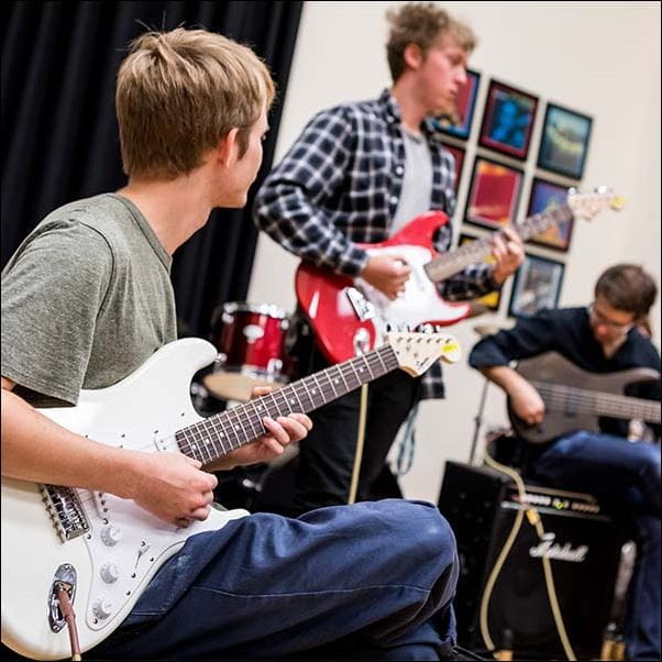 3 people playing guitar