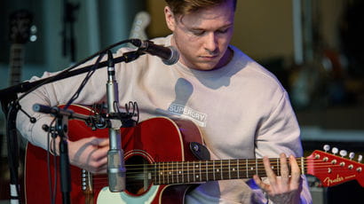 Singer songwriter singing and playing guitar