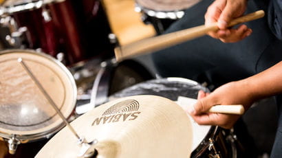 Closeup of someone playing the drums.