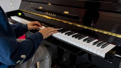 someone playing an upright piano.