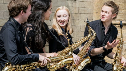 Group of saxophone players chatting outside 