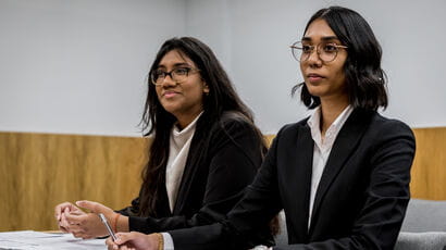 Two law students taking part in a trial a mock courtroom.