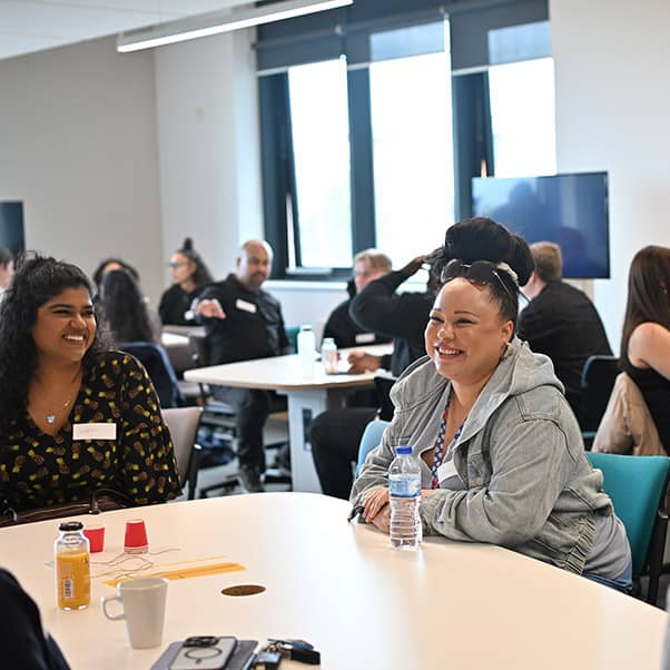 Groups of people working together at a social hackathon event.