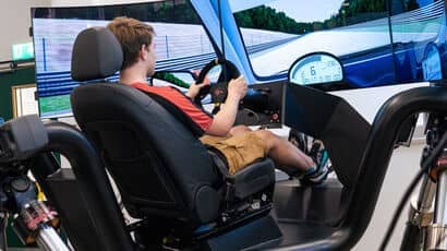 A student driving a simulation car.