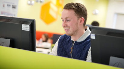 Student on computer smiling