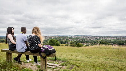 Three students on a bench overlooking Bristol.