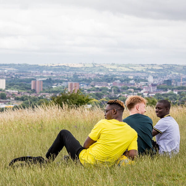 Students sitting in Stoke Park overlooking Bristol City Centre.