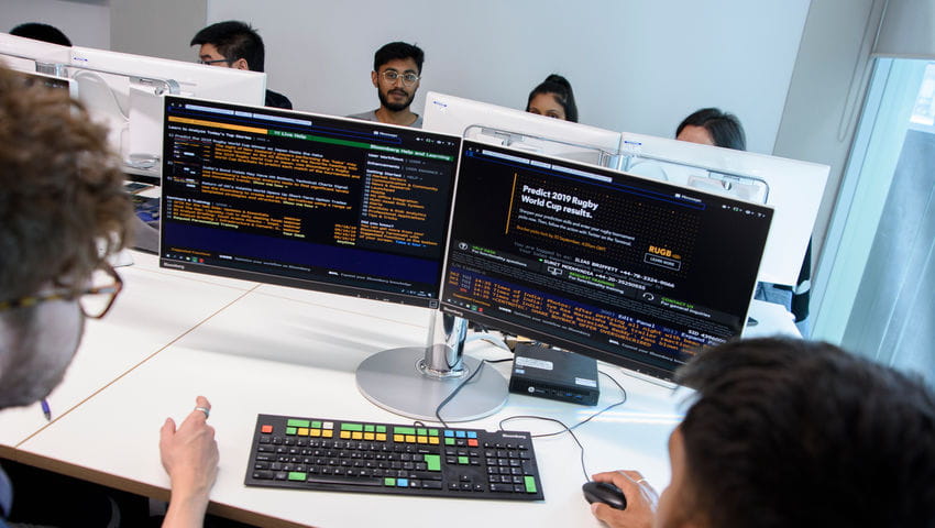 Students look at computers in the Bloomberg Room