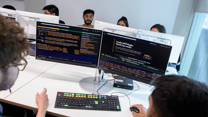 Students look at computers in the Bloomberg Room