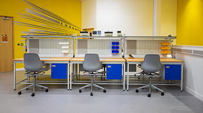 A row of three empty workbenches in Launch Space.