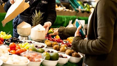 Someone buying produce at the university's fruit and veg stall.