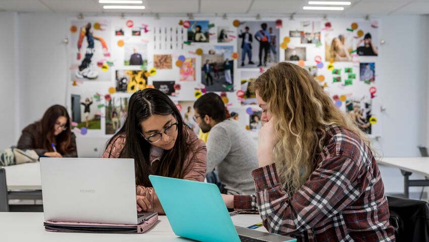 Couple of students looking at laptops