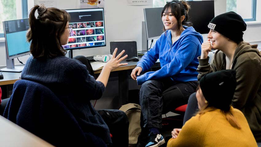 Students talking around the computer