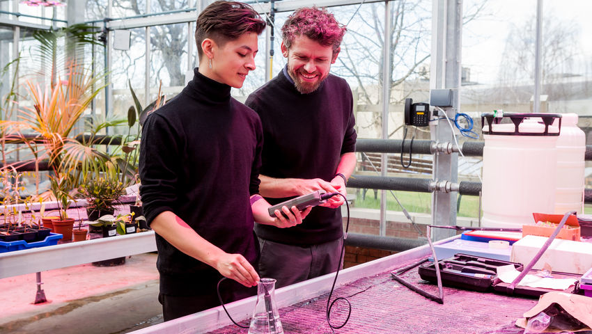 Two students in The Envirotron greenhouse