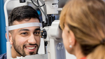 Student using eye clinic equipment.