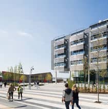 People walking past Bristol Business School building and the Students' Union building on Frenchay Campus