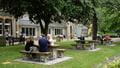 Students sitting outside on park benches in glenside grounds