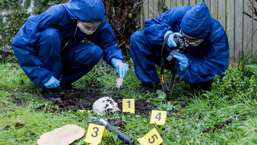 Forensic science students in protective clothing investigating a crime scene