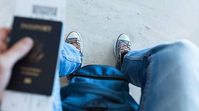 Person sitting in the airport holding their passport.