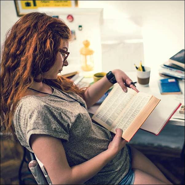 A student sat at a desk, reading.