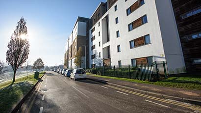 A road next to student accommodation with parked cars on UWE Bristol Frenchay Campus