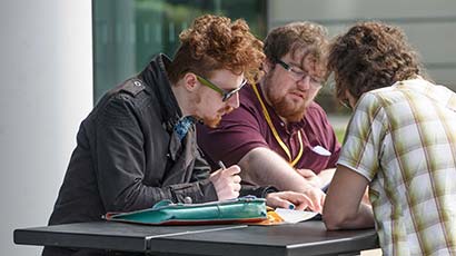 Group of students sat talking at a table