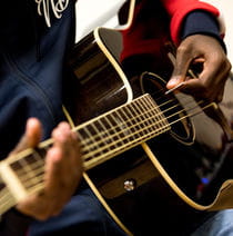 Closeup of someone playing guitar.