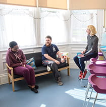 Three students chatting in the kitchen of student accommodation