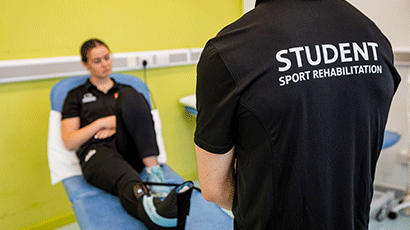 Patient on a bench performing ankle rehabilitation exercises.