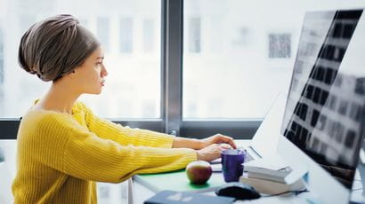 Person sat working at a large monitor screen.