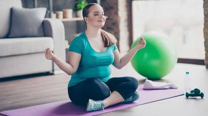 Woman meditating with yoga equipment