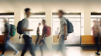 Motion blurred pictures of students walking along a corridor.