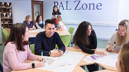 Group of student talking around a table.