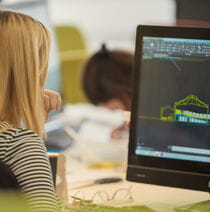 Female student using 3D modelling software to build a structure.