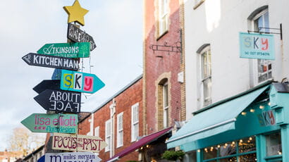 A signpost with colourful arrows pointing in lots of directions.