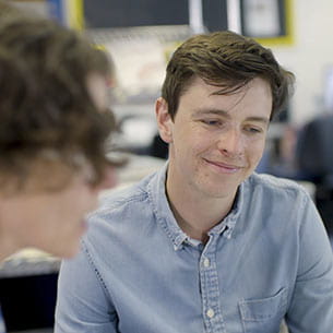 Smiling person having a conversation with someone inside.