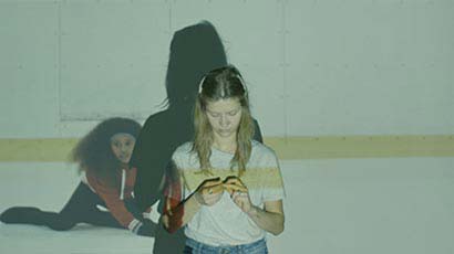 girl looking at her hands standing in front of a light projection