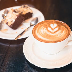 Coffee cup and cake on a table.