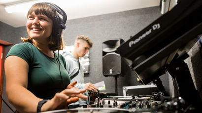 Student with headphones on the decks