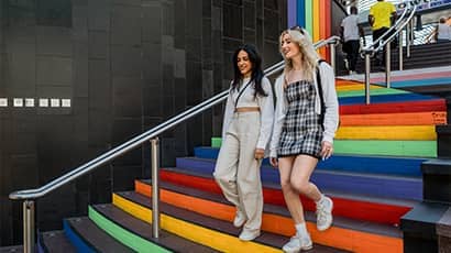 Students walking down colourful steps in Cabot Circus shopping centre.