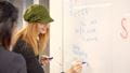 Students writing on the white board in the Maths Hub