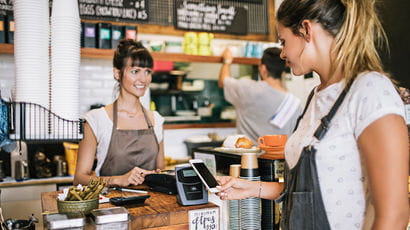 A person paying at a coffee shop